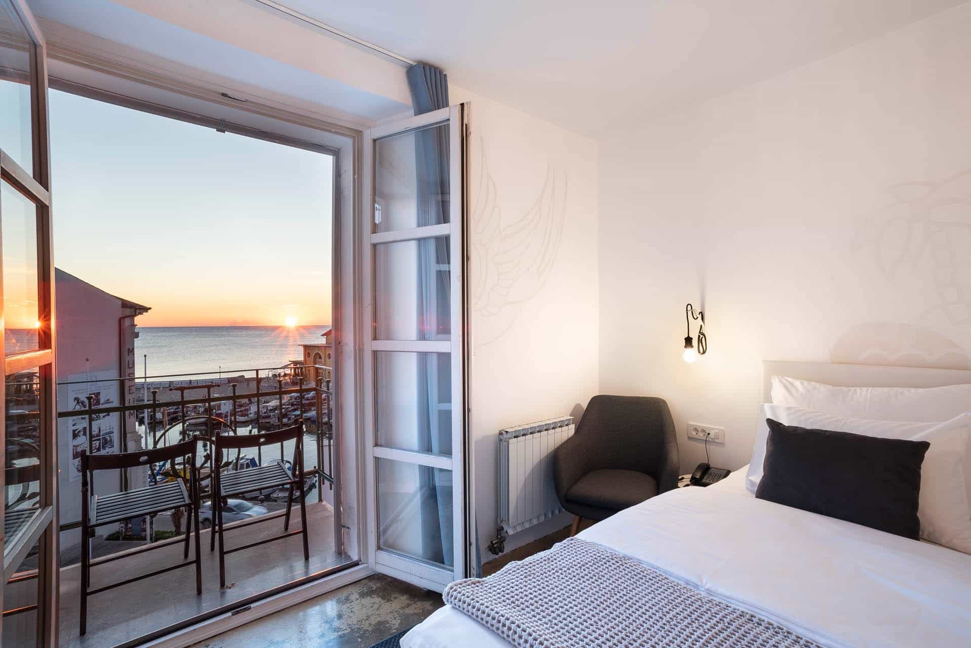 Hotel room with balcony view of sea sunset over harbor, Tartini square area