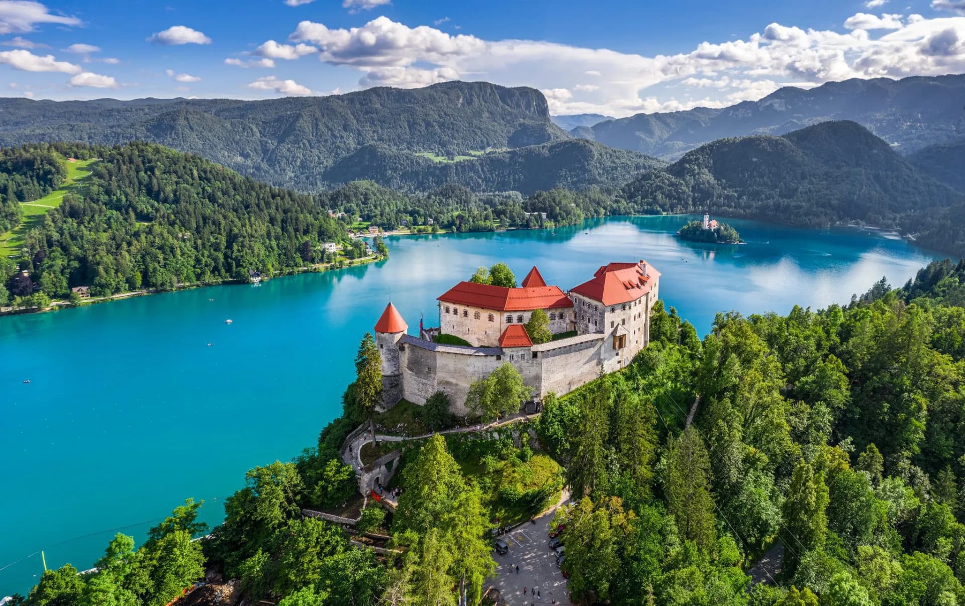 Bled Castle overlooking turquoise Lake Bled with island church and Julian Alps in background