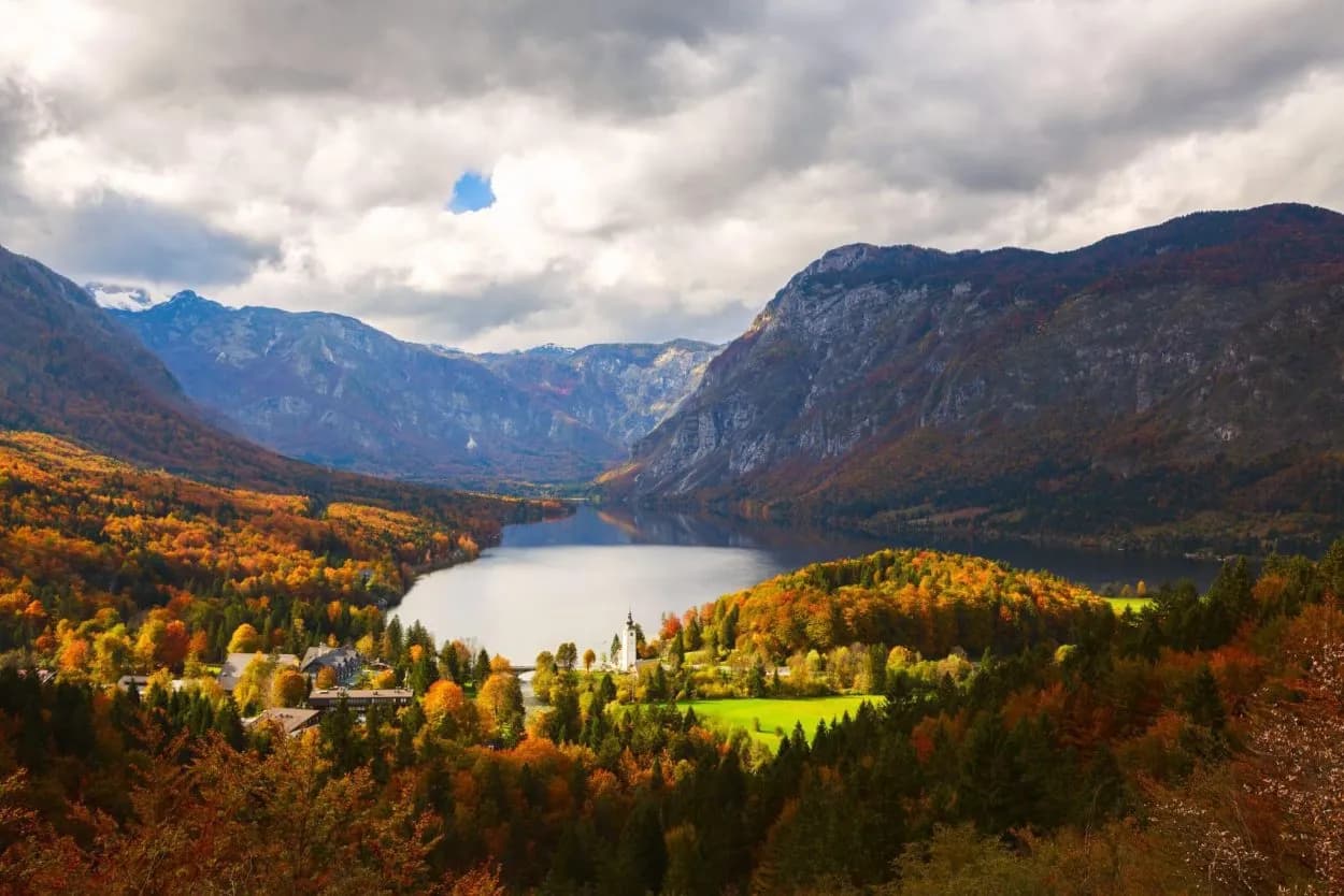 Lake Bohinj in Triglav National Park with autumn foliage and dramatic clouds